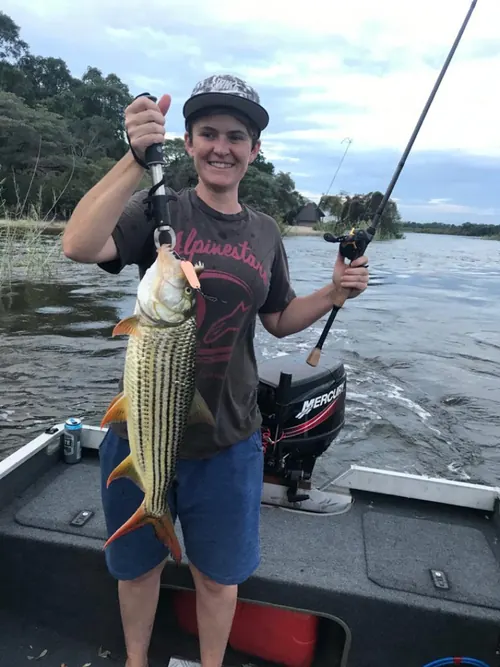 Angler holding a tigerfish on a boat
